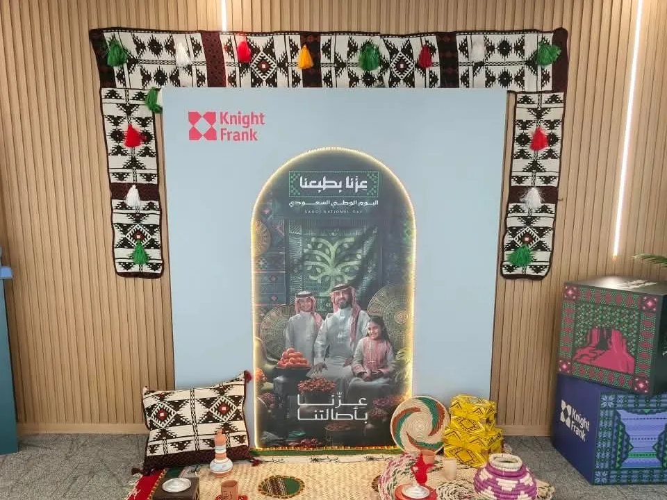 Corporate National Day setup in Riyadh with a printed backdrop, Sadu textile frame and branded display boxes